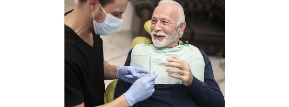 Stock photo of a denture patient in the dental operatory with their dentist. 